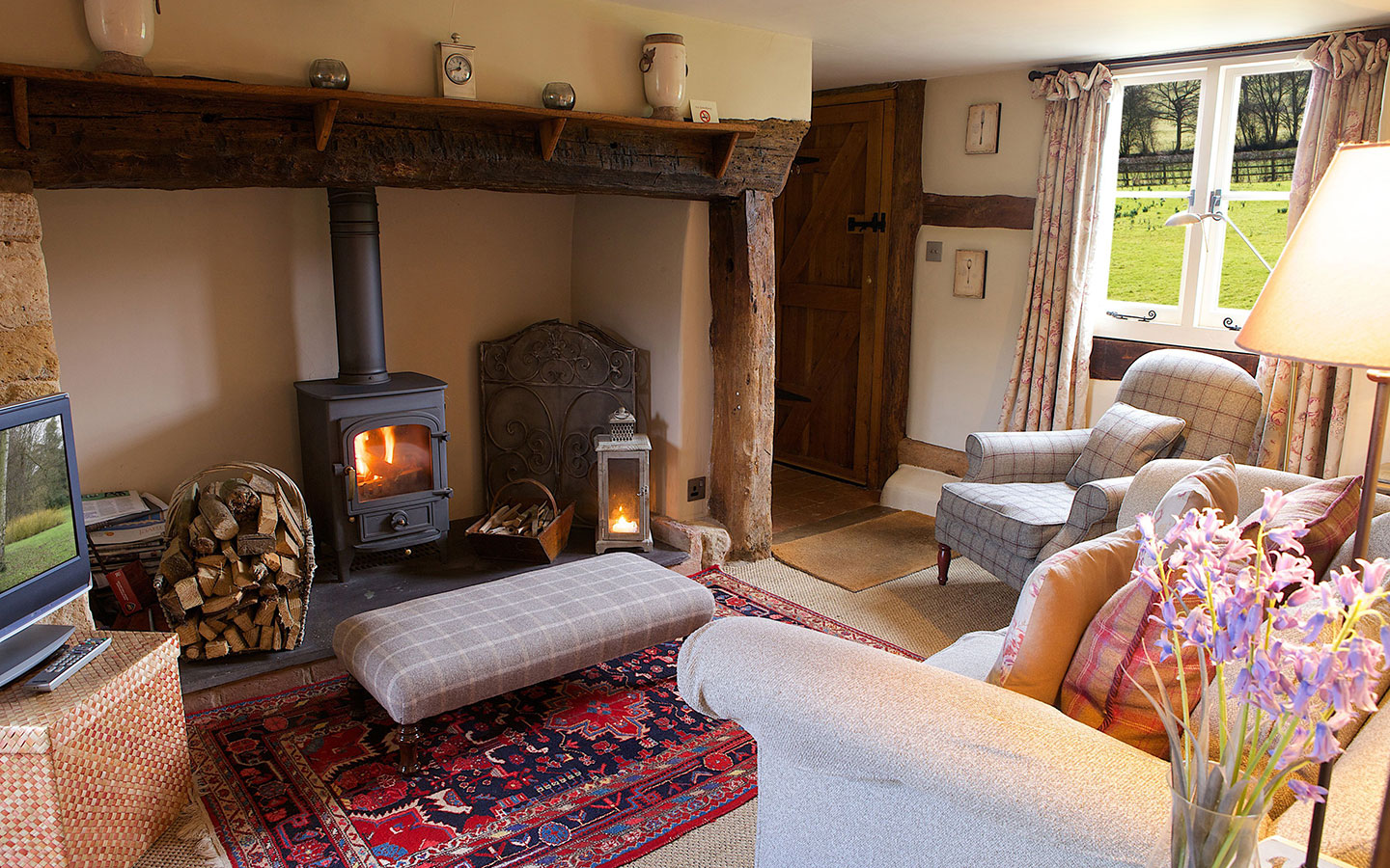 The cosy lounge with woodburning stove at Field Cottage in the Cotswolds