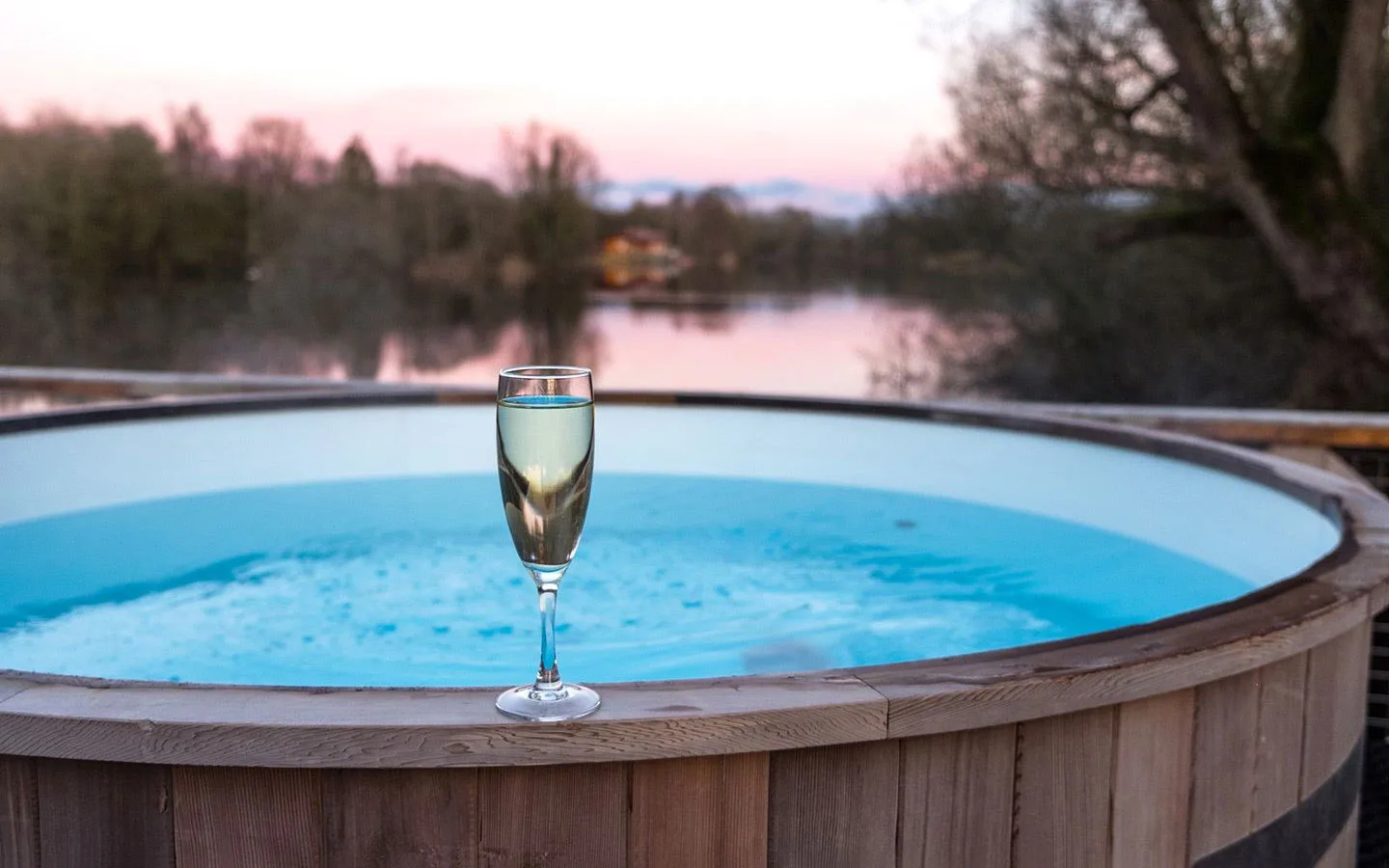Prosecco by the hot tub at sunset at Log House Holidays