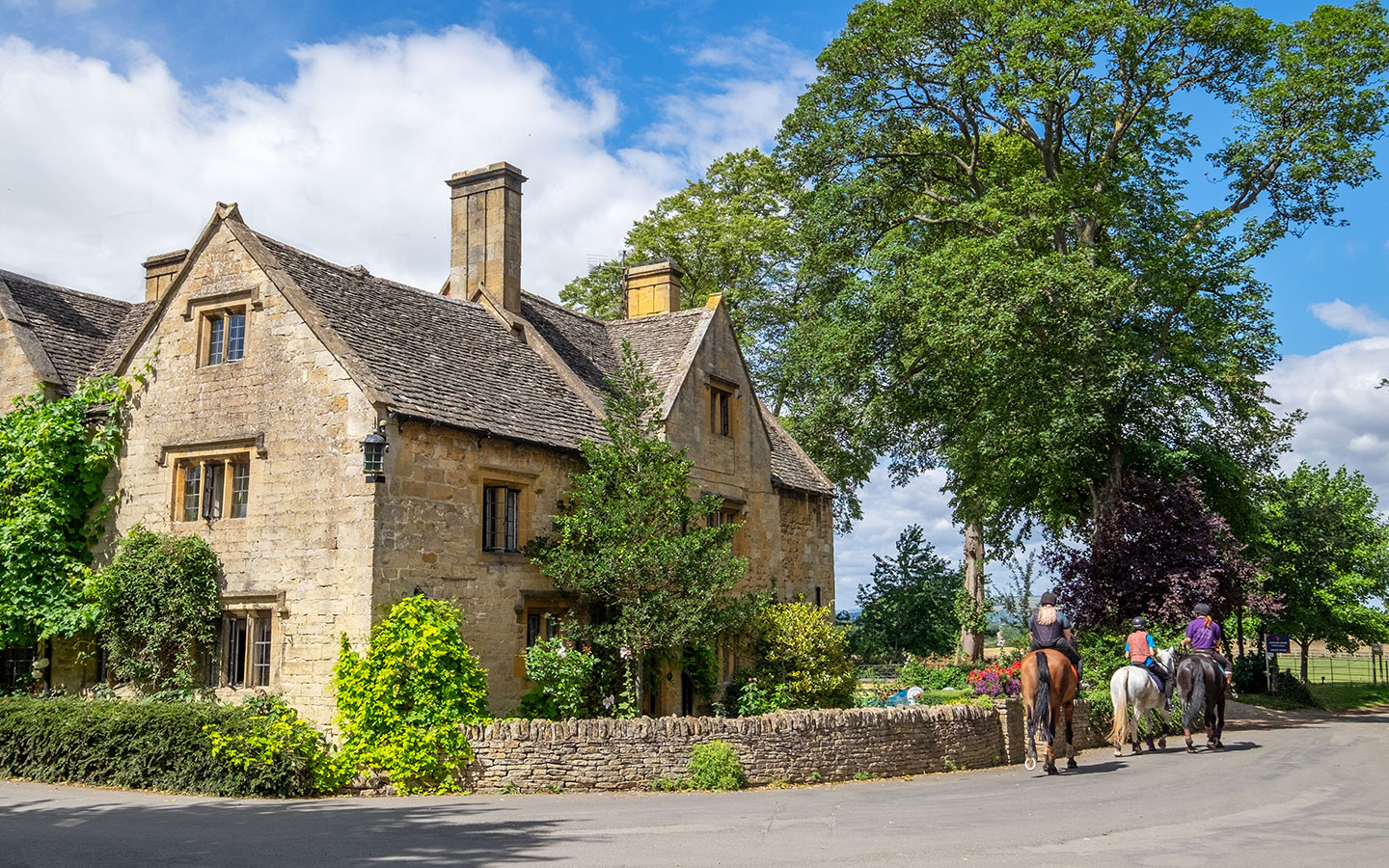 Horses and riders in Stanton village in the Cotswolds