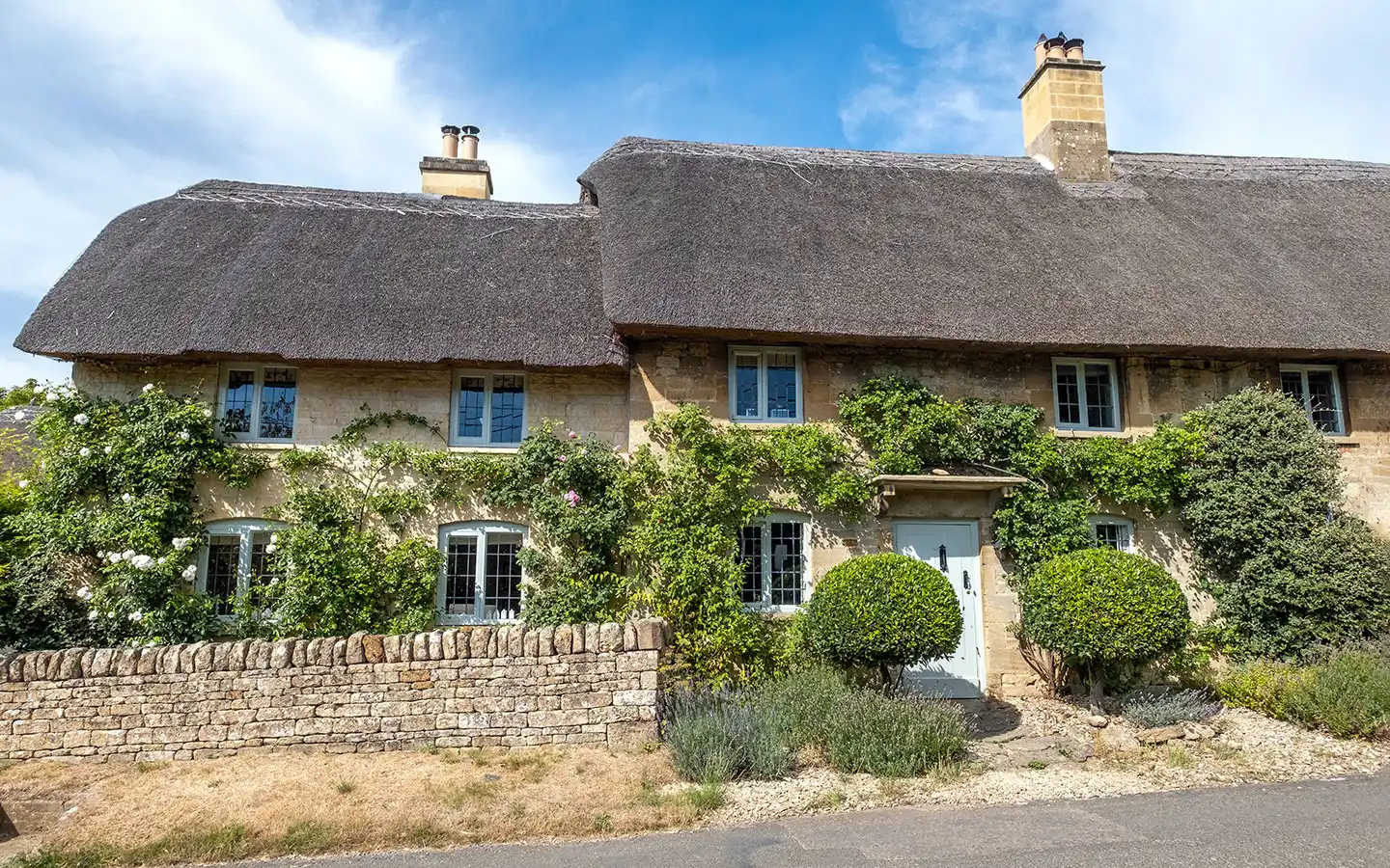 Row of pretty thatched cottages in Taynton near Burford in summer